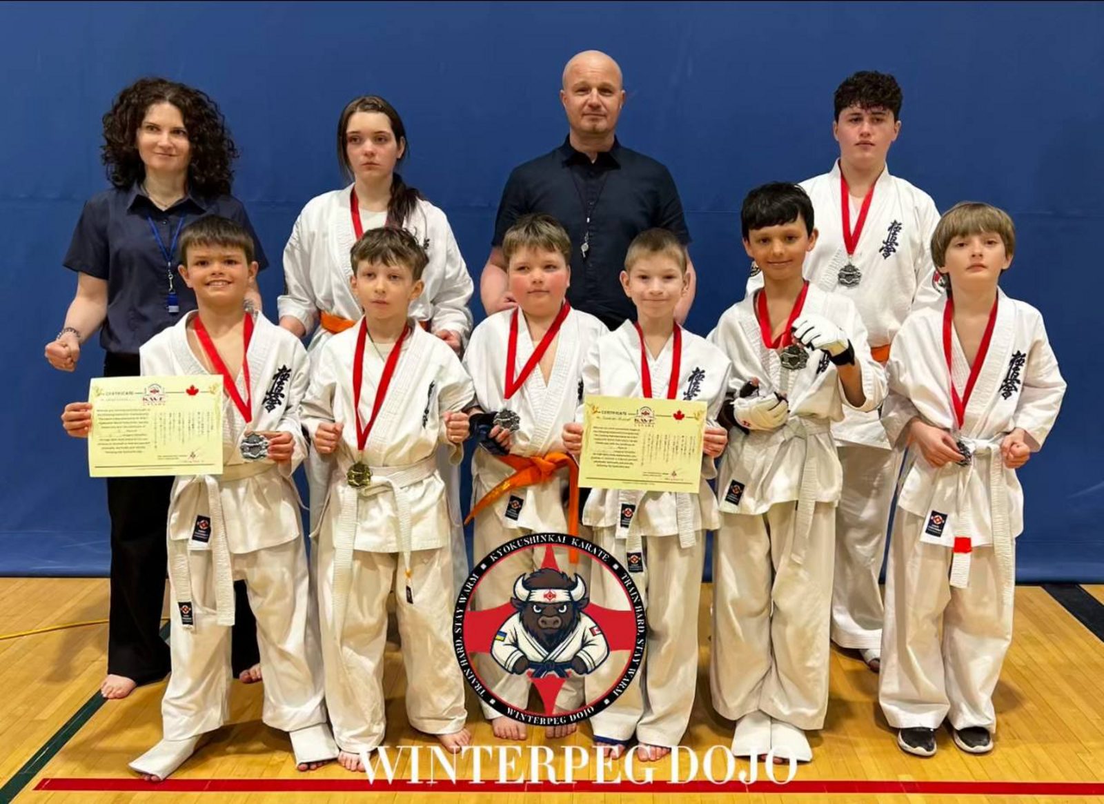 Winterpeg Dojo students proudly displaying their medals and certificates after a successful karate tournament